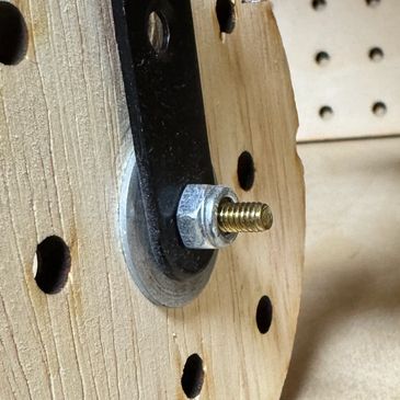 Bolt and nut securing a metal bracket to a wooden surface.