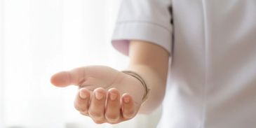 Person in white uniform extending an open hand forward.