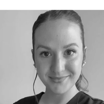 Smiling woman with natural makeup and neat hair against a plain background.
