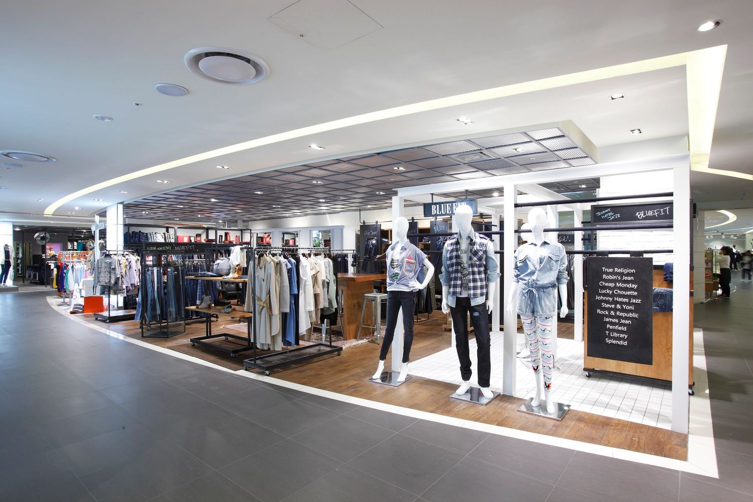 Modern clothing store with mannequins and racks of apparel.