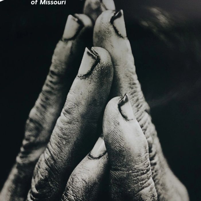 Hands clasped in a black-and-white photograph