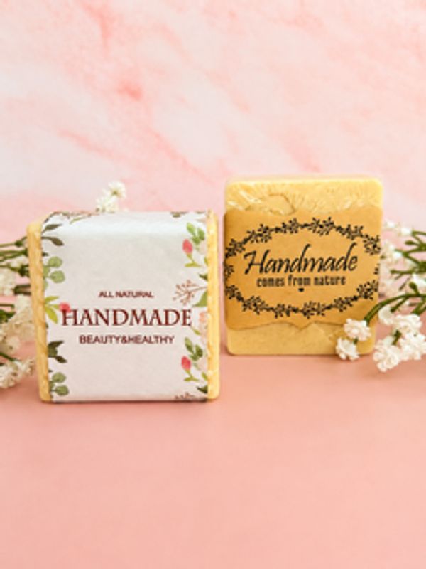 Two handmade soap bars with floral labels.