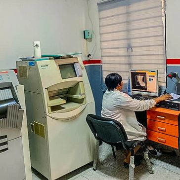 A technician operating an X-ray machine in a medical lab.