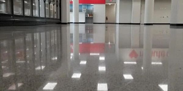 Highly polished floor reflecting ceiling lights in a spacious commercial interior.