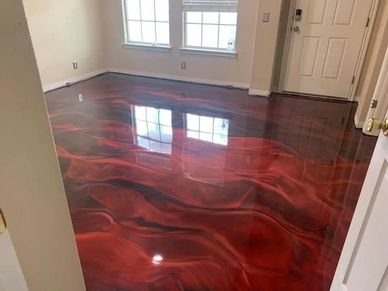 A room with glossy, red and black swirled epoxy flooring reflecting the window.