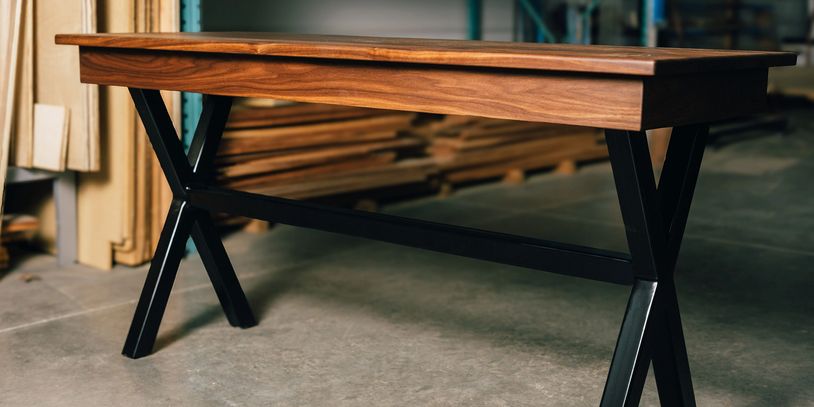 Wooden table with black metal legs in a workshop.