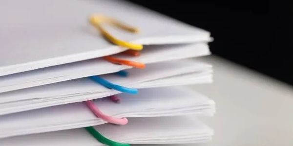 Stack of documents with colorful paper clips.