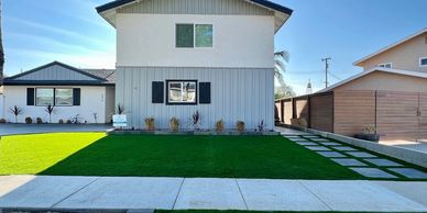 Front yard of house with artificial turf and pavers