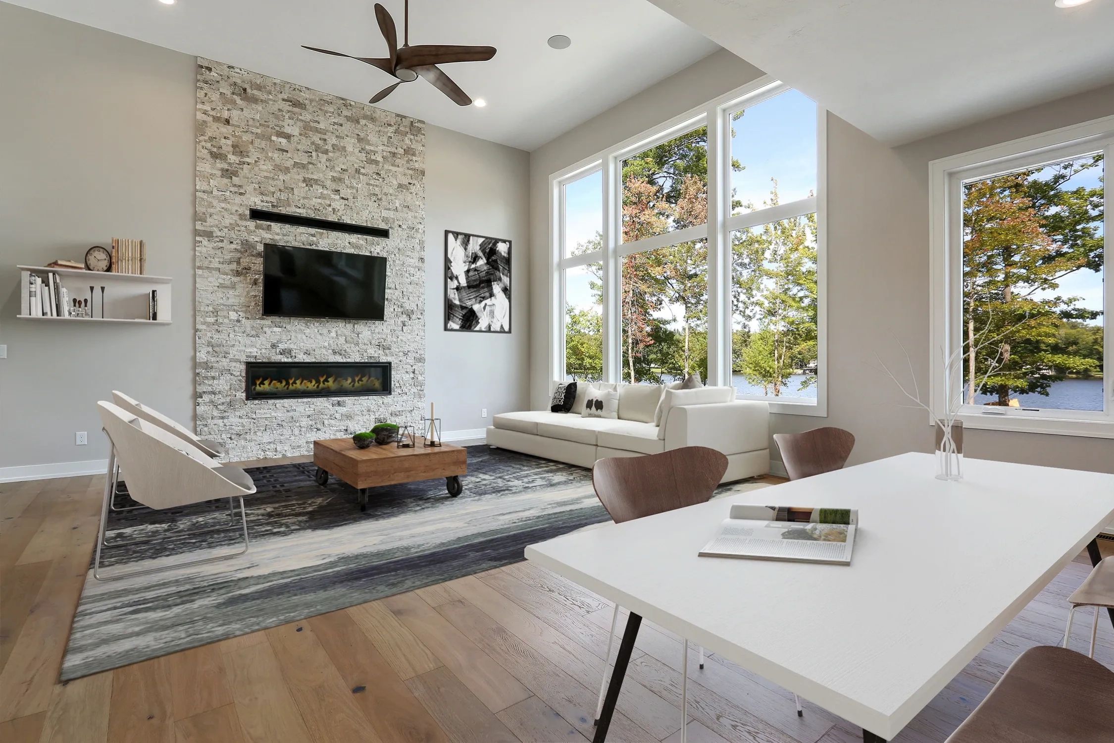 Living room area with tall ceilings, floor to ceiling modern stone fireplace and dining area