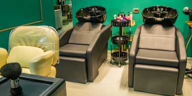 Haarsalon mit zwei Waschbecken und Stühlen.