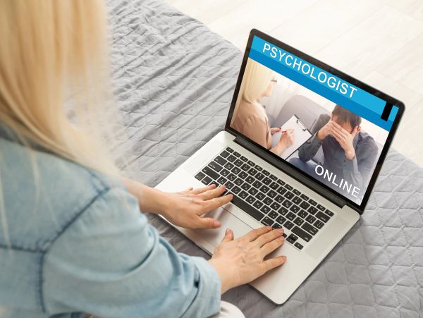 Woman accessing online psychologist consultation on laptop.