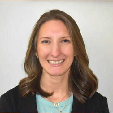 Smiling woman with shoulder-length hair in professional attire.