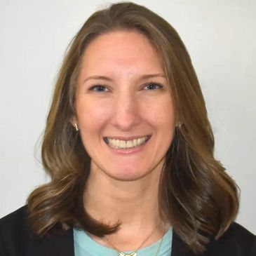 Smiling woman with shoulder-length hair in professional attire.