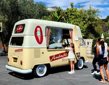 Vintage ice cream truck serving customers outdoors.