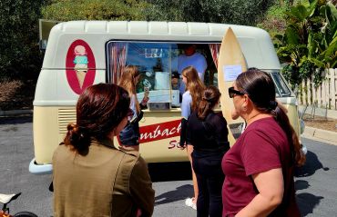 People waiting in line at an ice cream truck.
