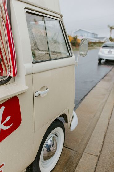 Close-up of vintage van door with striped curtain.