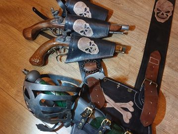 Pirate-themed costume accessories including flintlock pistols, a helmet, and belts with skull and crossbones designs.