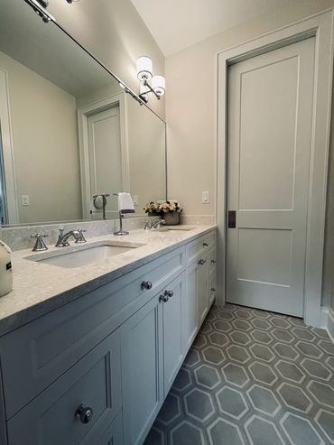 Painted custom cabinets, Kohler polished chrome fixtures and honeycomb floor tile.