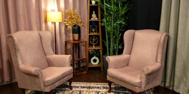 Cozy room with two beige armchairs and decorative plants.