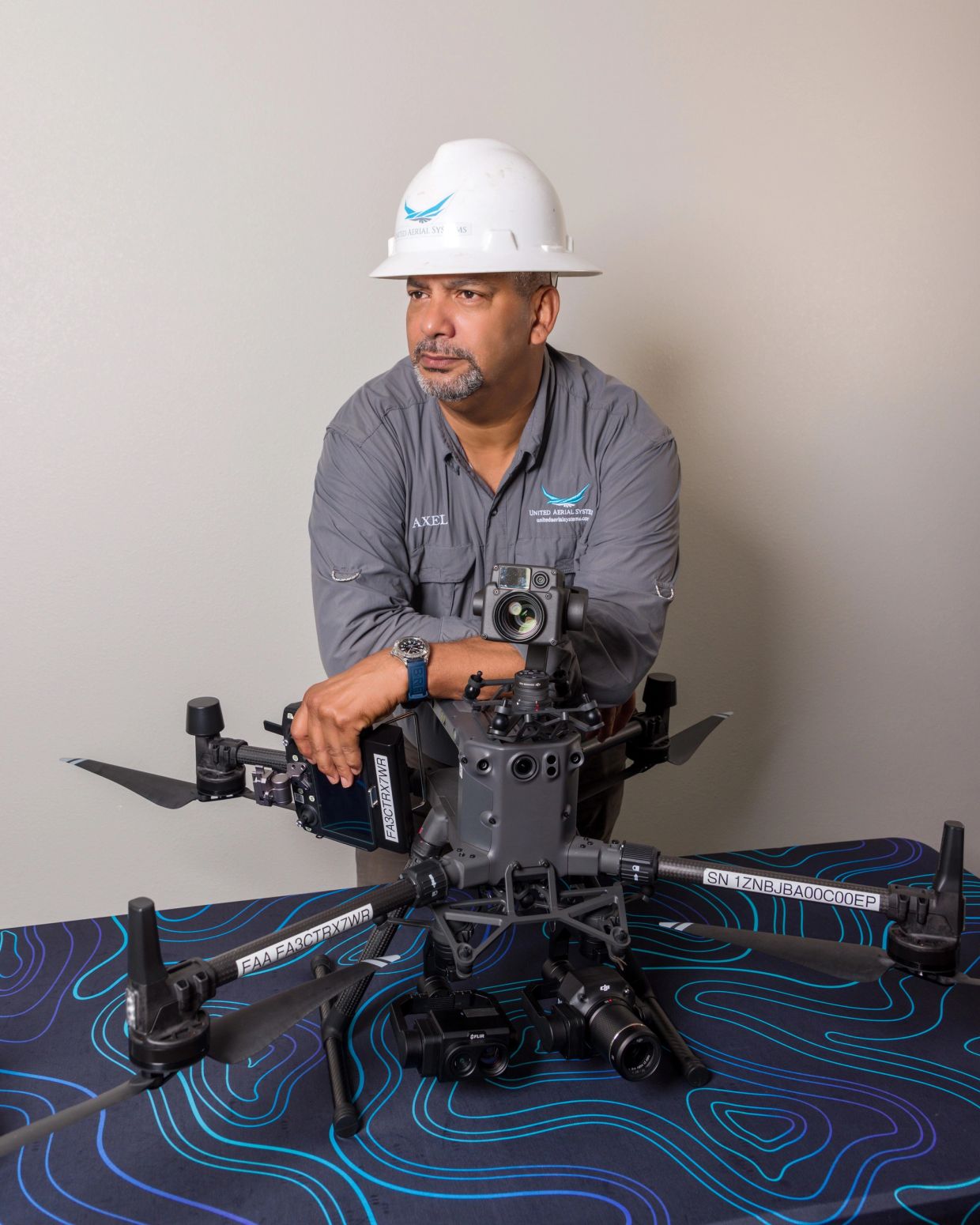 Man in hard hat with drone on table.