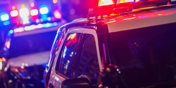 Close-up of police vehicles with flashing lights at night.