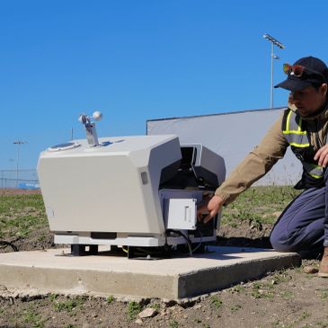 Technician operating outdoor scientific equipment.