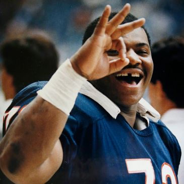 Football player making an OK gesture and smiling.