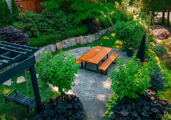 Basalt stone retaining wall, outdoor dining, pergola, lawn area, bluestone stepping stone walkway