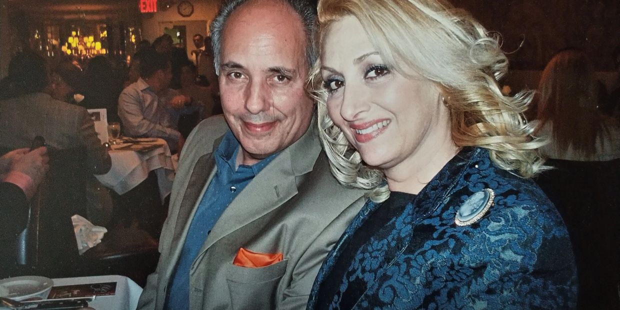 Smiling couple posing at a restaurant with warm lighting.
