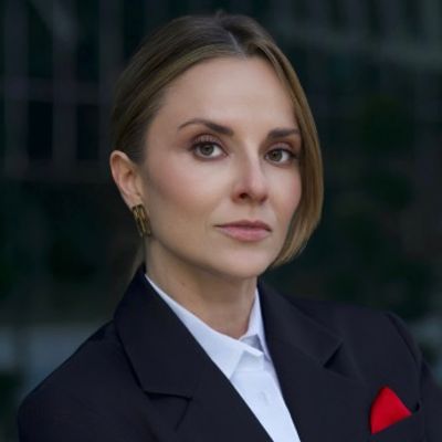Confident woman in professional attire with a subtle smile.