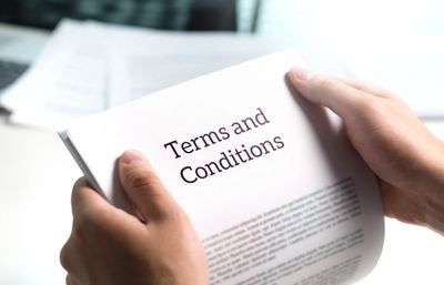 Person holding a document titled "Terms and Conditions".