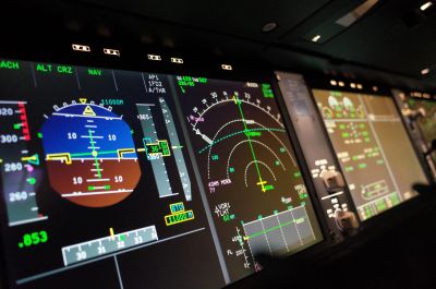 Close-up of aircraft cockpit displays showing flight instruments.