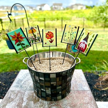 Fused Glass Garden Stakes in a Mosaic Wine Bucket, a display of student work