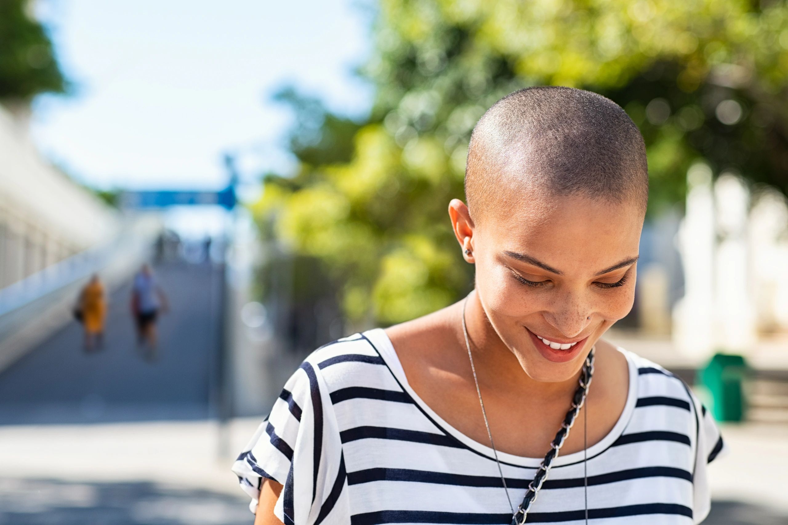 An attractive smiling young woman with very short hair