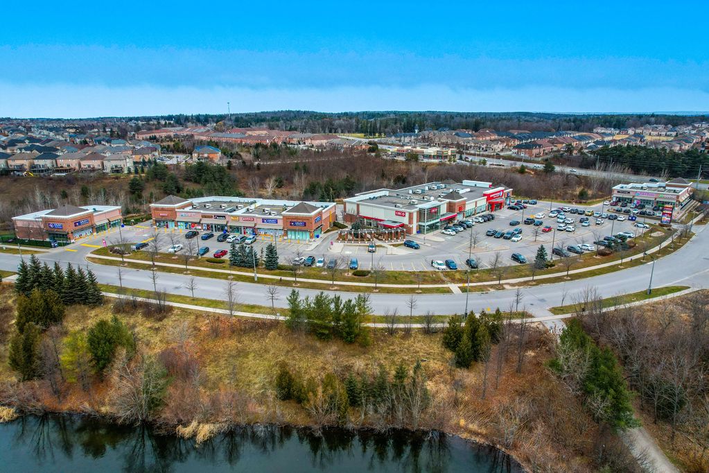 A suburban shopping plaza with parking lots and surrounding residential areas.