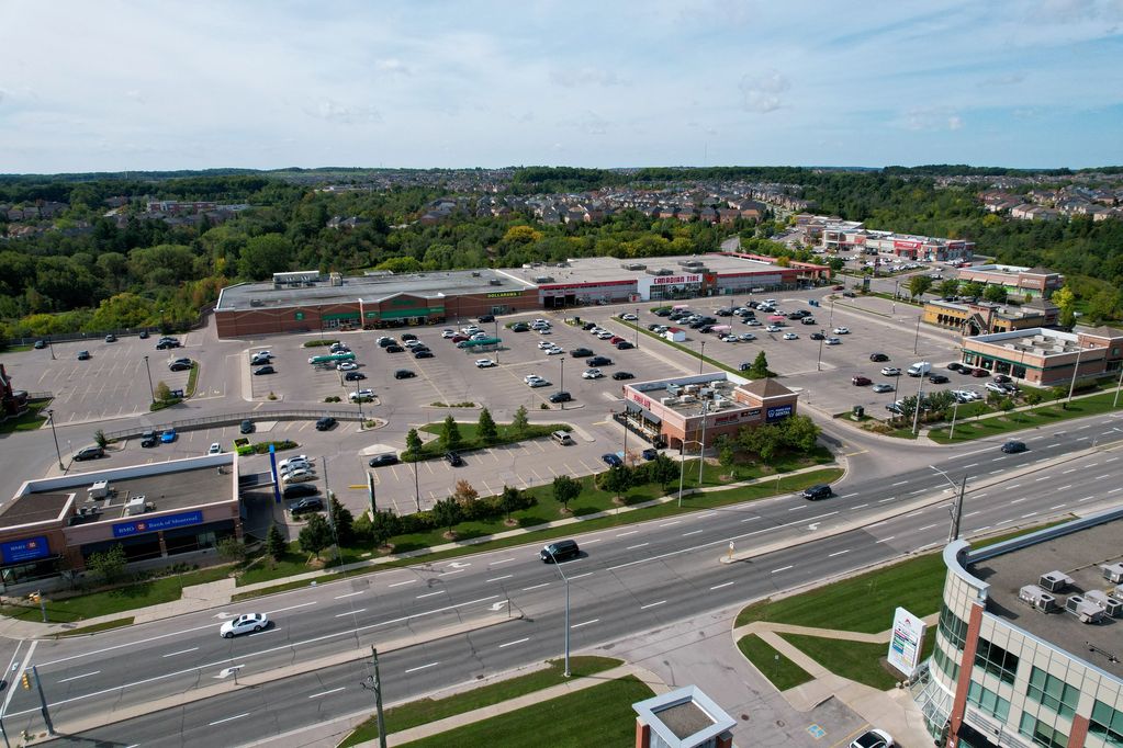 A large shopping plaza with multiple stores and a spacious parking lot.