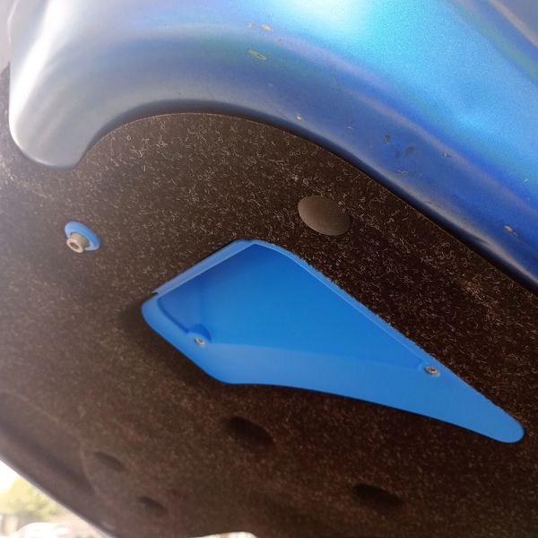 Blue engine bay insulation panel on a car hood interior.
