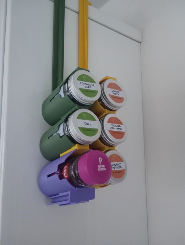 Magnetic spice jars neatly organized on a vertical rack against a white background.