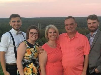 Eccleston family smiling with a rural sunset behind them