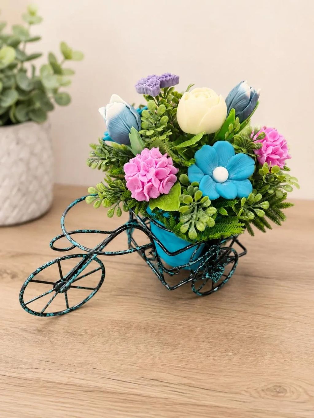 Decorative blue tricycle flower pot with colorful flowers.