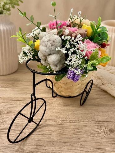 Decorative flower arrangement in a small tricycle basket.
