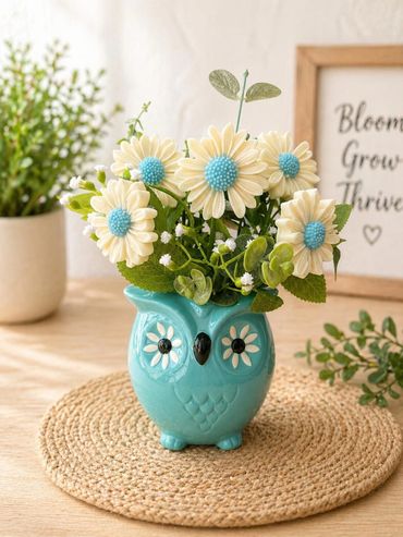Blue owl vase with daisy flowers centerpiece.