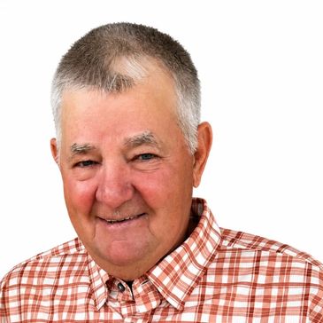Smiling elderly man in a plaid shirt.