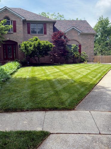 BBN Lawn Care team trimming edges and maintaining flower beds