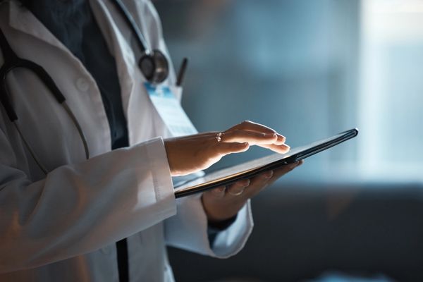 A healthcare professional using a tablet