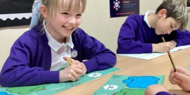 Children in purple uniforms smiling and writing at school.