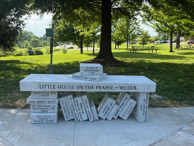 Bench designed as stacked books in a park.
