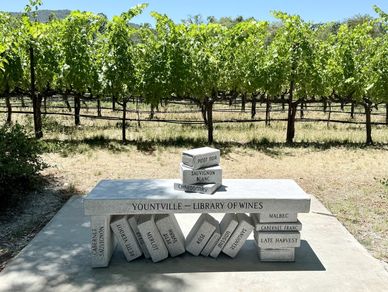 A bench designed like giant wine corks in a vineyard.
