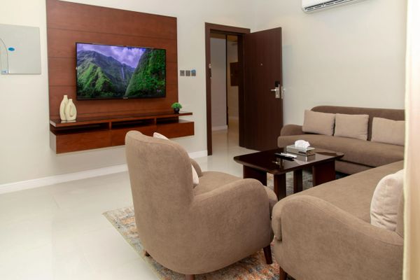 Cozy living room with brown sofas, a wall-mounted TV, and a wooden coffee table.
