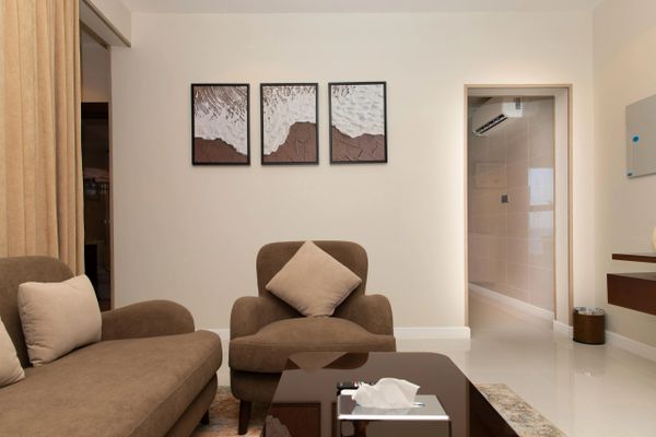 Cozy living room with brown sofa set and abstract wall art.